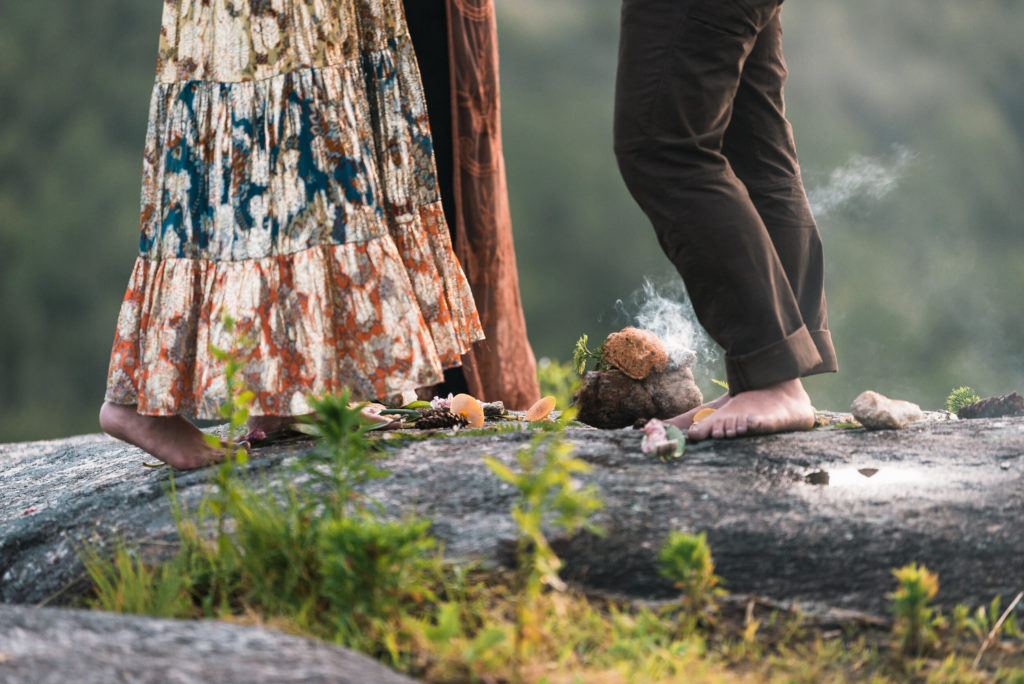Picture of a couple eloping in their bare feet while burning sage in the North Carolina mountains.
