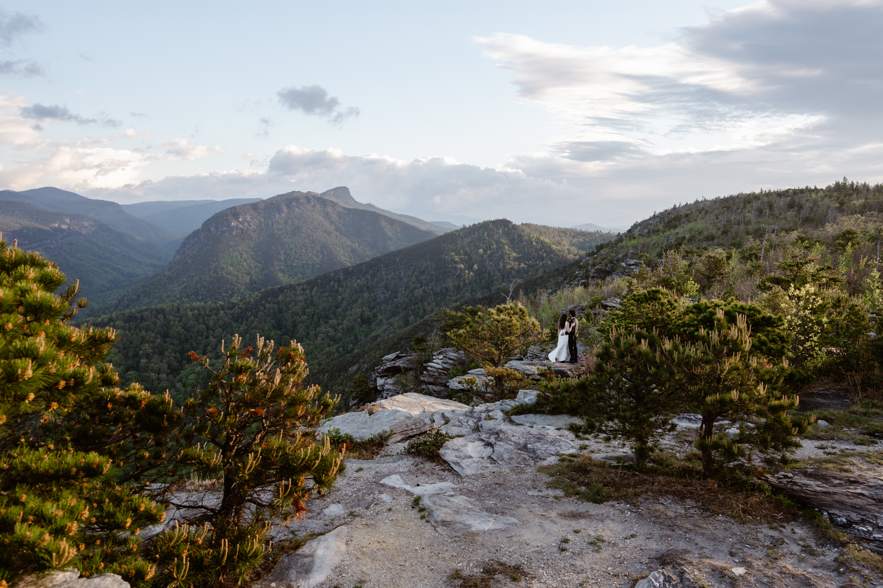 Eloping couple standing in the mountains near Linville Gorge Wilderness after their elopement